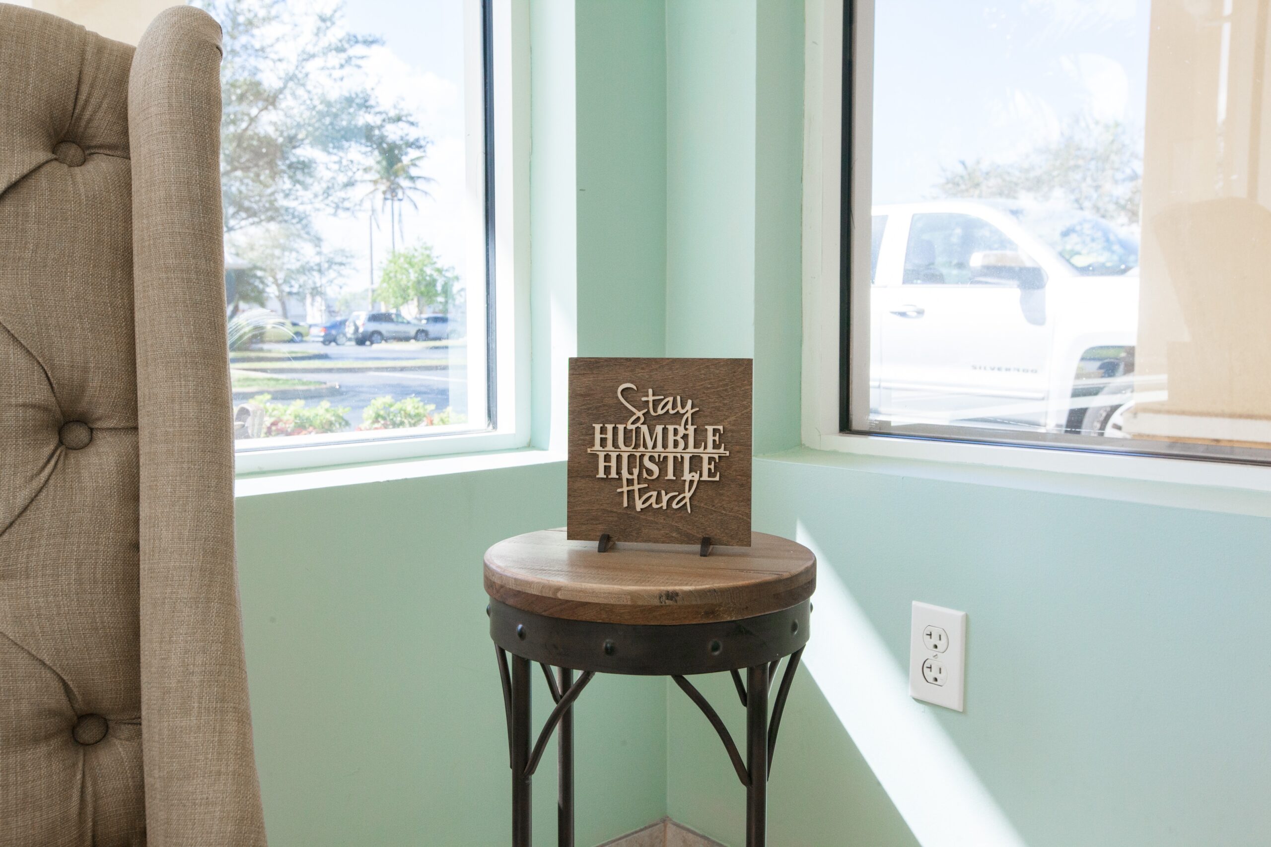 Florida Facilities stay humble hustle hard wood carving on side table
